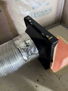 施工中　新しい換気扇のダクトアダプターにじゃばらダクトを取り付けます